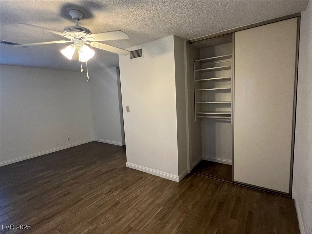 3737 Prosperity Lane Las Vegas, NV 89147 - Photo 26 of 36 Unfurnished bedroom featuring dark wood-style floors, a textured ceiling, a ceiling fan, and a closet