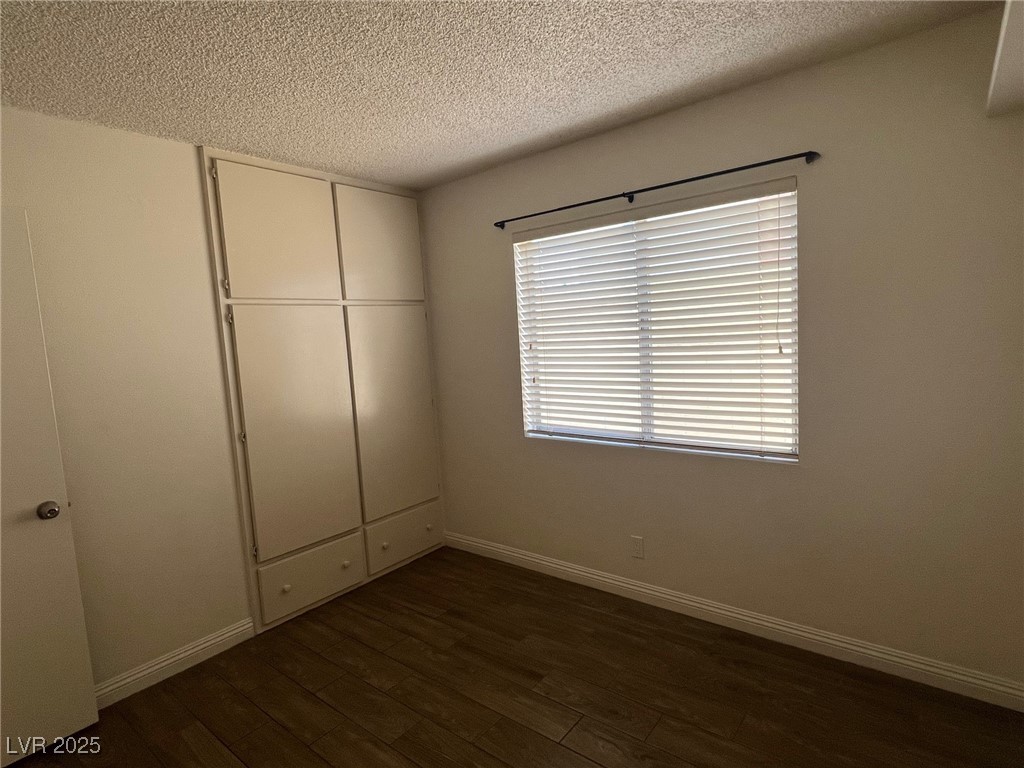 3737 Prosperity Lane Las Vegas, NV 89147 - Photo 27 of 36 Unfurnished bedroom with a textured ceiling, dark wood finished floors, and a closet