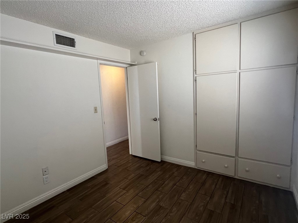 3737 Prosperity Lane Las Vegas, NV 89147 - Photo 28 of 36 Unfurnished bedroom with a textured ceiling, dark wood-style floors, and a closet
