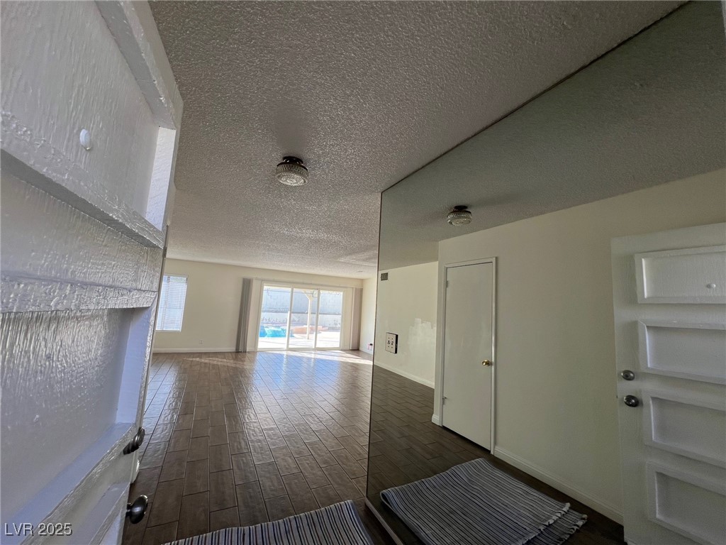 3737 Prosperity Lane Las Vegas, NV 89147 - Photo 5 of 36 Unfurnished living room with a textured ceiling and dark wood-style flooring