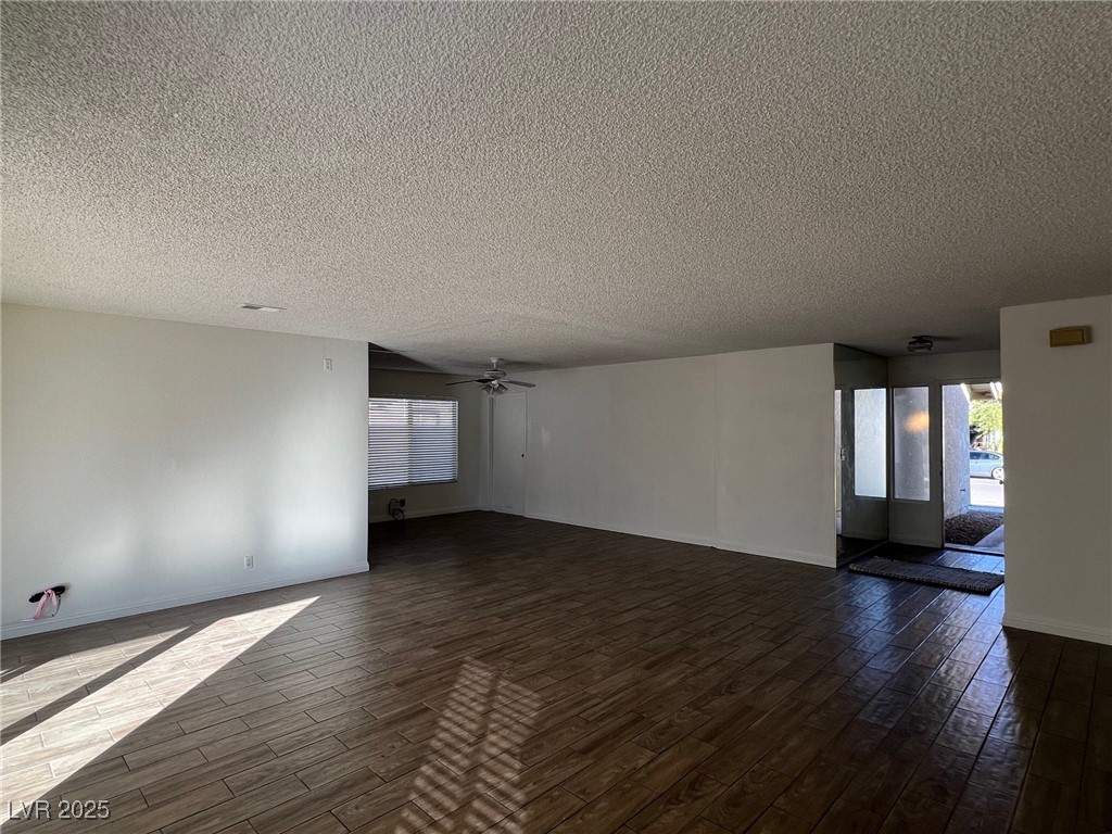 3737 Prosperity Lane Las Vegas, NV 89147 - Photo 7 of 36 Empty room with dark wood-style flooring, a textured ceiling, and a ceiling fan