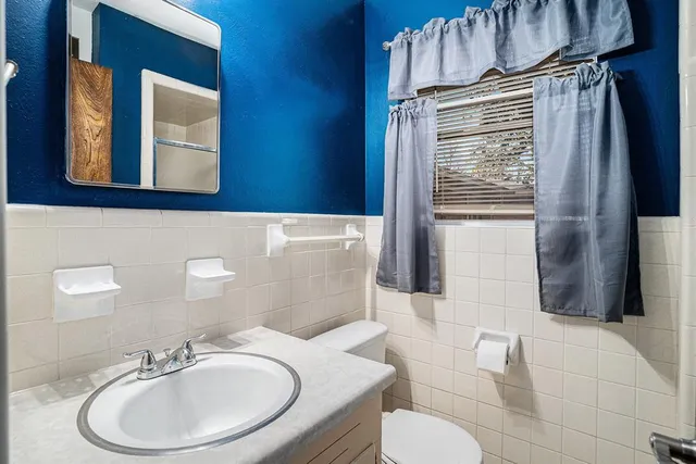 a bathroom with a sink a toilet and mirror