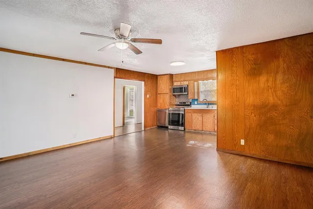 a view of a kitchen with wooden floor and a ceiling fan