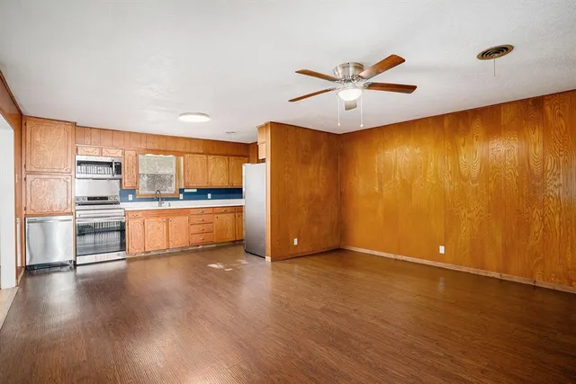 a view of a kitchen with wooden floor and a window