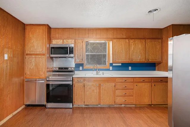 a kitchen with stainless steel appliances a stove a sink and a refrigerator
