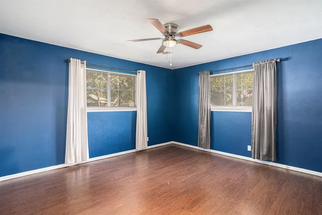 a view of a big room with wooden floor and windows