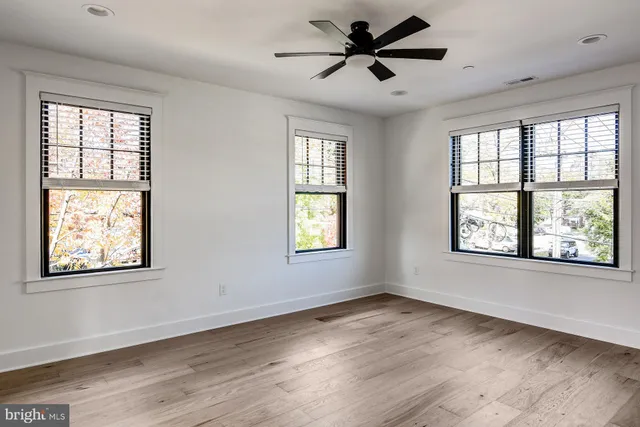 a view of an empty room window and wooden floor