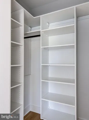 a view of walk in closet with empty racks