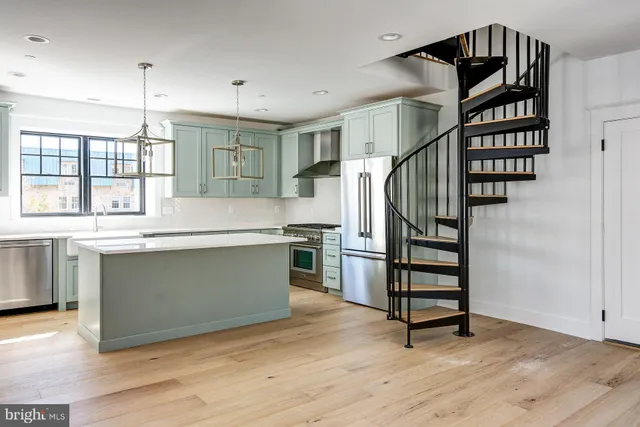 a kitchen with stainless steel appliances cabinets and wooden floor