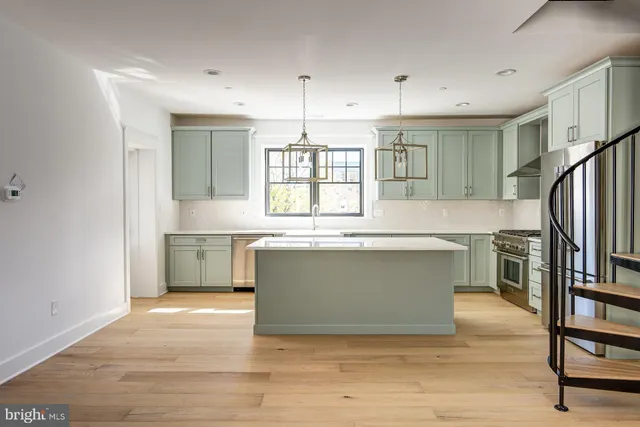 a view with a kitchen island wooden cabinets and stainless steel appliances