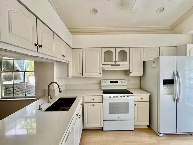 a kitchen with white cabinets and white appliances