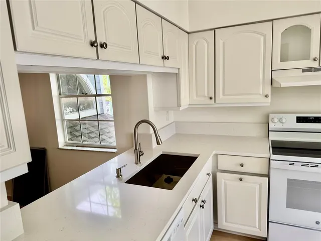 a kitchen with white cabinets and white appliances