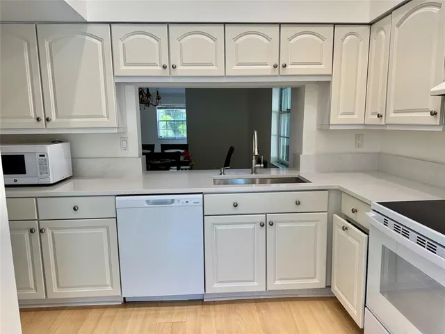 a kitchen with white cabinets and a sink