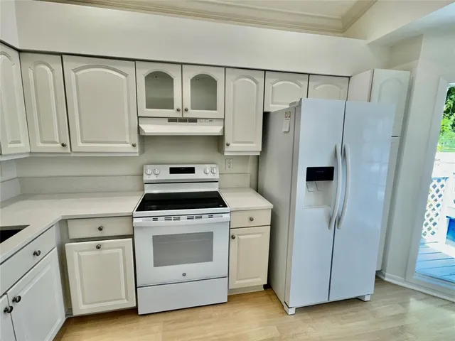 a kitchen with white cabinets and white appliances