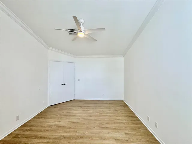 a view of empty room with wooden floor