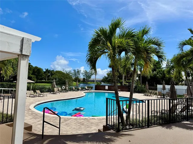 a view of swimming pool with lounge chair and dinning table under an umbrella