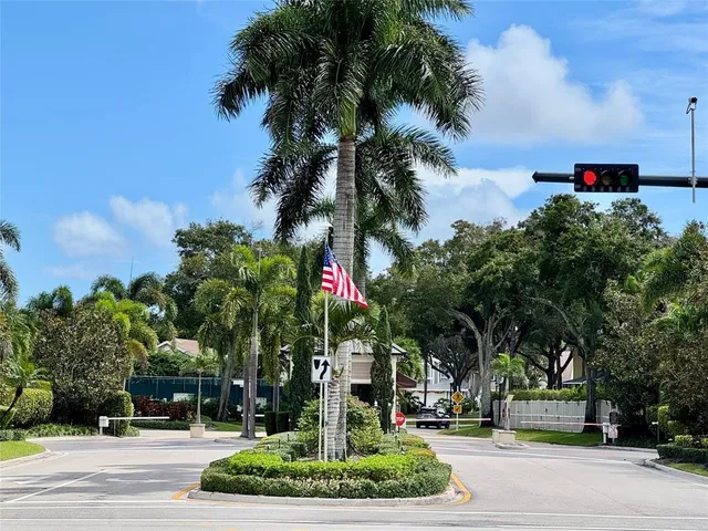 a front view of multi story residential apartment building with yard and sign board