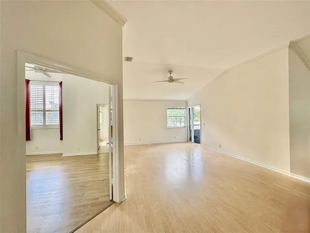 a view of empty room with wooden floor