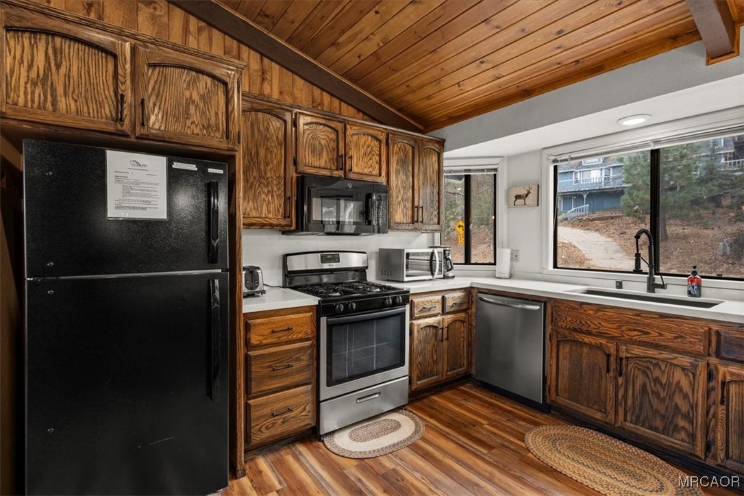 1414 Klamath Road Big Bear City, CA 92314 - Photo 8 of 28 a kitchen with stainless steel appliances granite countertop a refrigerator a sink dishwasher a stove with wooden cabinets and floor