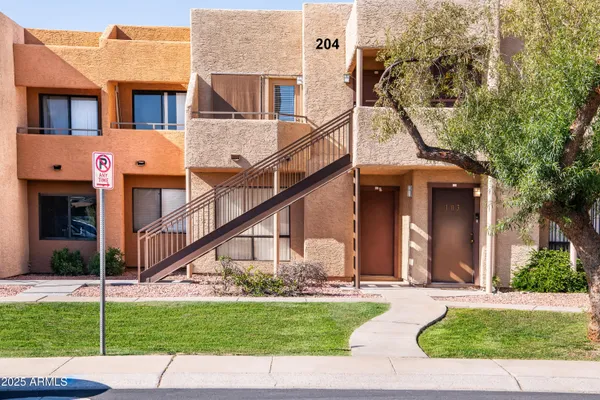 a view of a brick house with a yard and plants