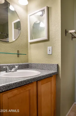 a bathroom with a granite countertop sink and a mirror