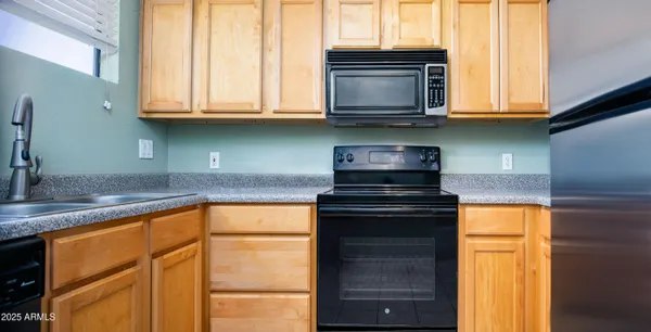 a kitchen with stainless steel appliances granite countertop wooden cabinets and a stove top oven