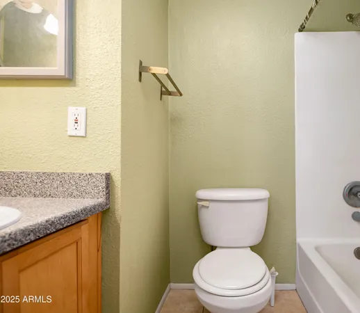 a bathroom with a granite countertop toilet a sink and a bathtub