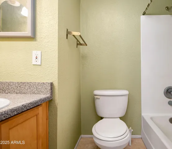 a bathroom with a granite countertop toilet a sink and a bathtub