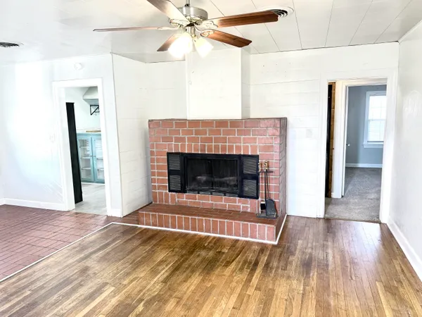 a living room with a fireplace and wooden floor
