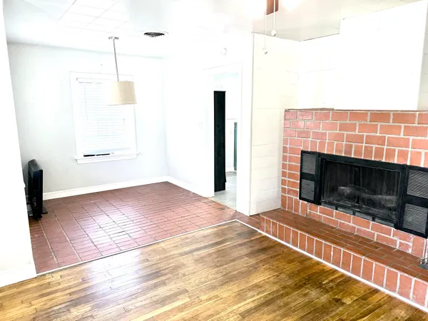a view of empty room with wooden floor and fireplace