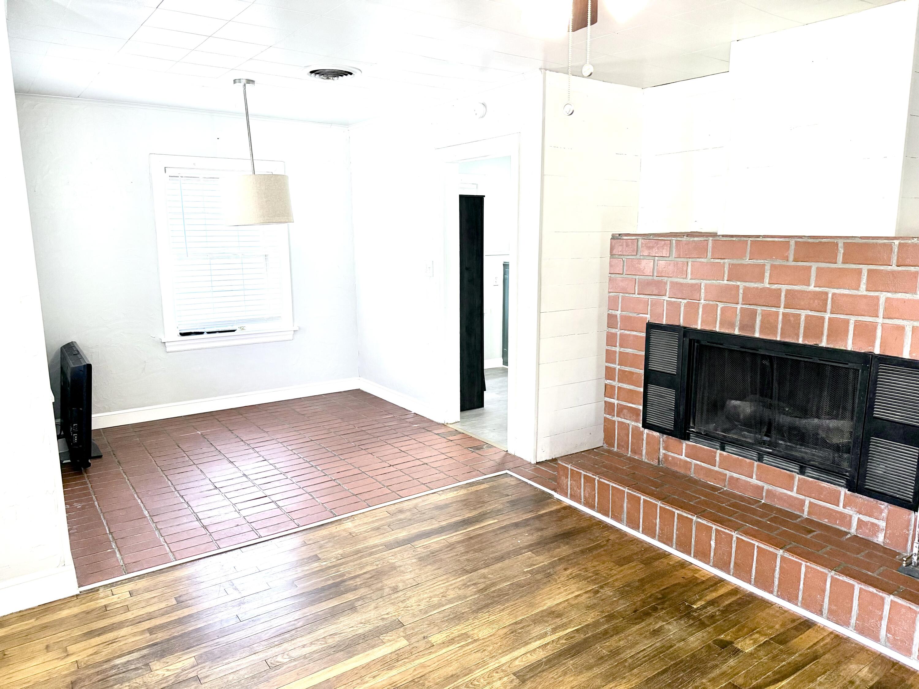 1906 25th Street Lubbock, TX 79411 - Photo 4 of 24 a view of empty room with wooden floor and fireplace