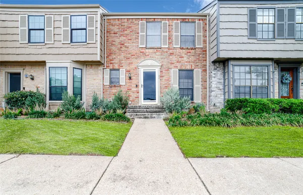 front view of a brick house with a yard