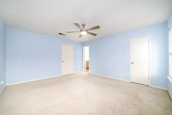 a view of an empty room with a ceiling fan