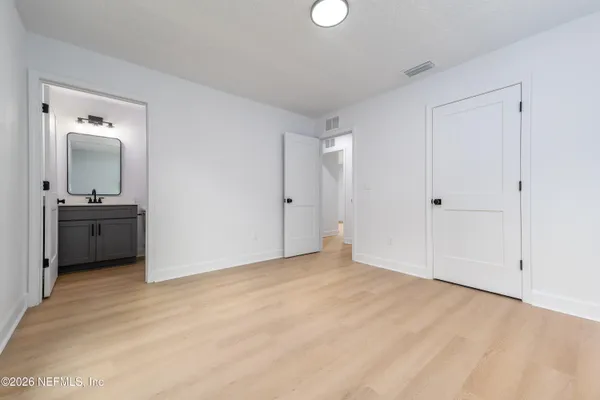 a view of an empty room with window and bathroom