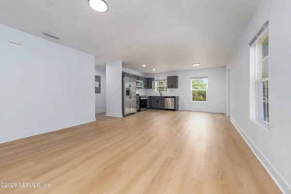 a view of empty room with a fireplace and window