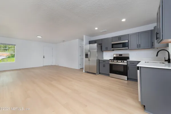 a kitchen with stainless steel appliances kitchen island granite countertop a stove a sink and a refrigerator
