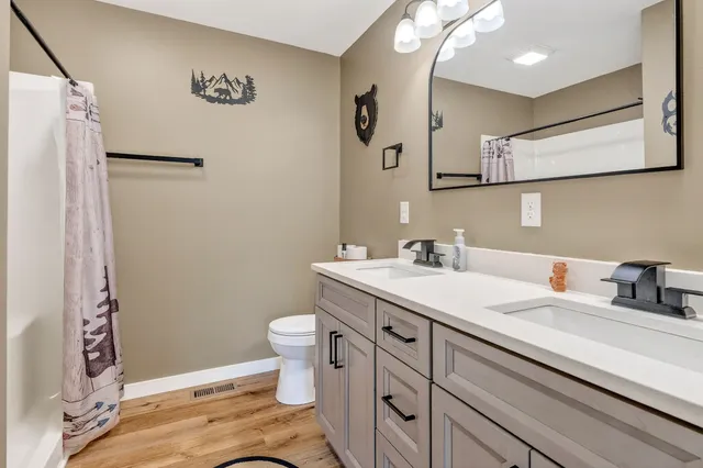 a bathroom with a granite countertop sink toilet and shower