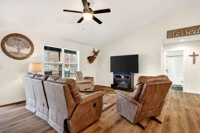 a living room with furniture a flat screen tv and a window
