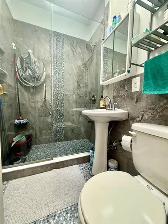 a bathroom with a sink a toilet and shower