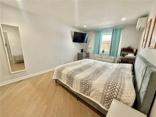 a bedroom with a bed window and a flat screen tv