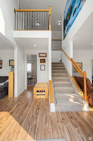 12645 East Cedar Ridge Drive Fairview, UT 84629 - Photo 4 of 34 Grand entryway featuring wood-finish flooring, a carpeted staircase with wood handrails and black balusters, and a high-ceiling open landing