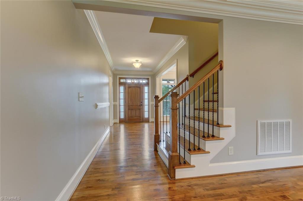 8501 Billet Place Oak Ridge, NC 27310 - Photo 3 of 30 Beautiful foyer with introduction to the dining room, gleaming hardwood floors and transoms over windows.