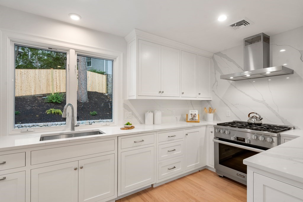 30 Clinton Road Brookline, MA 02445 - Photo 15 of 19 a kitchen with a stove a sink a window and cabinets