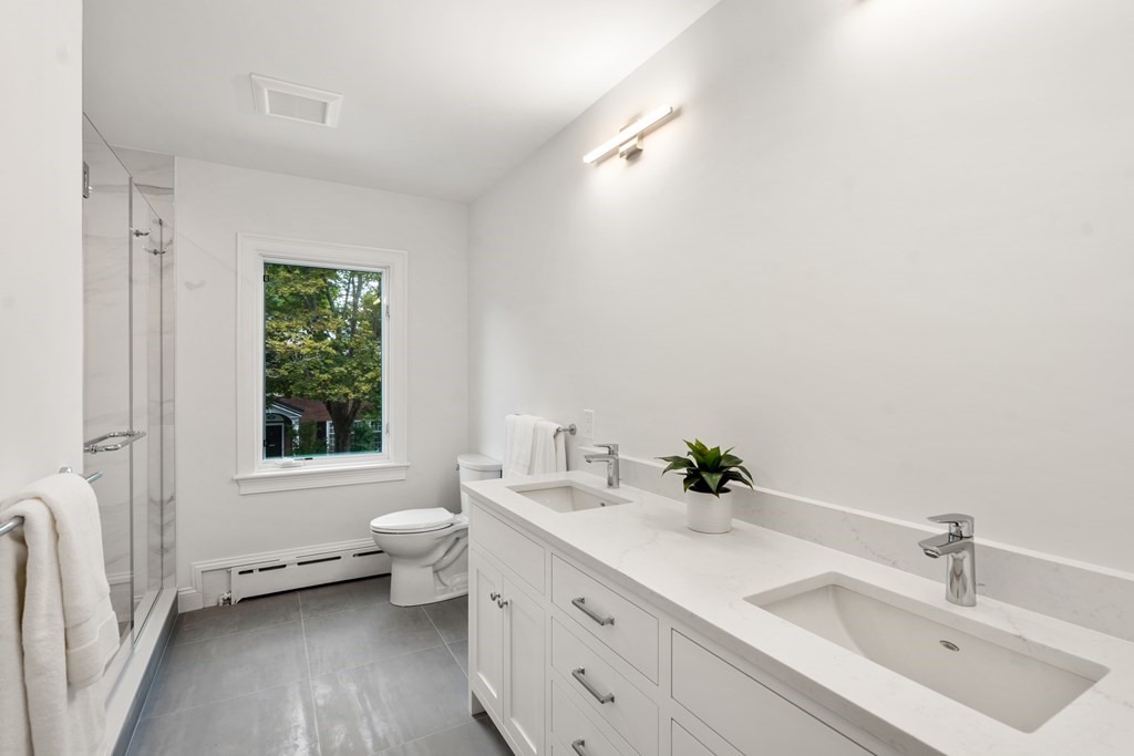 30 Clinton Road Brookline, MA 02445 - Photo 18 of 19 a bathroom with a double vanity sink toilet and a window