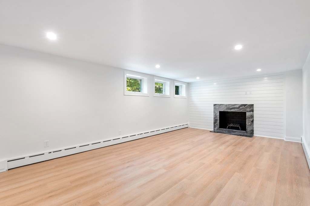 30 Clinton Road Brookline, MA 02445 - Photo 19 of 19 a view of an empty room with a fireplace and a window
