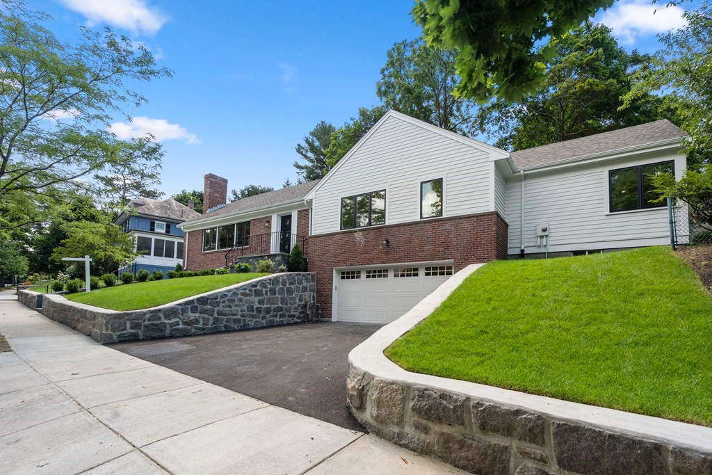 30 Clinton Road Brookline, MA 02445 - Photo 2 of 19 a front view of a house with a yard and potted plants