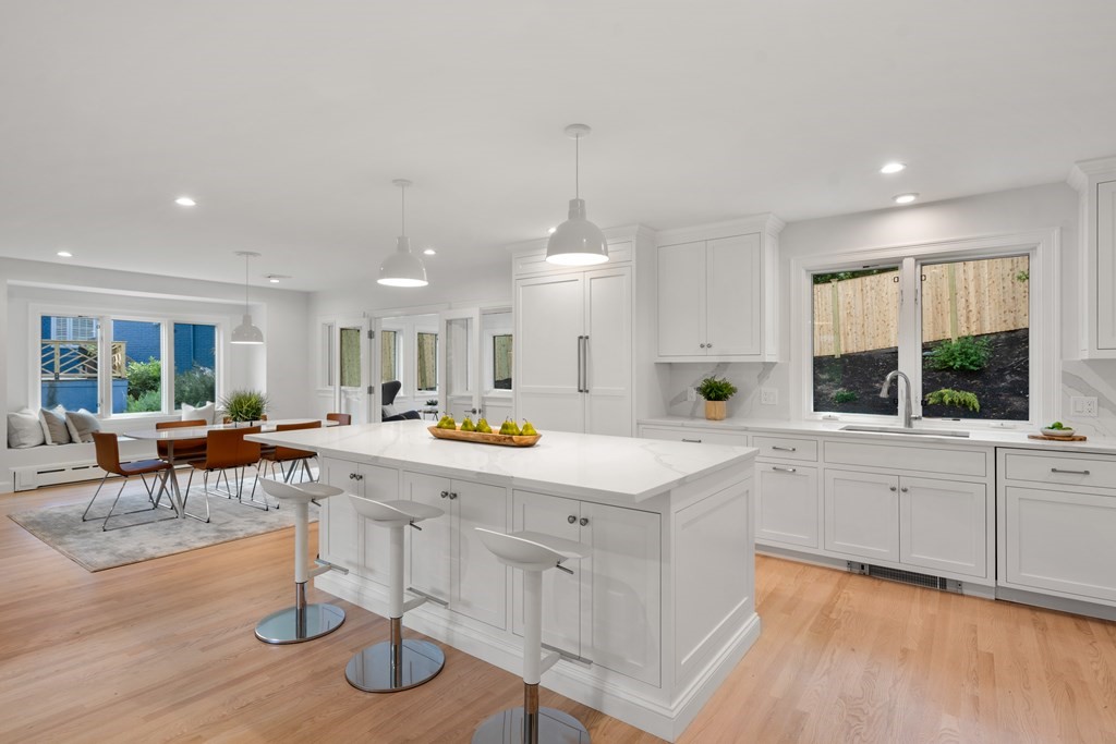 30 Clinton Road Brookline, MA 02445 - Photo 7 of 19 a large white kitchen with lots of counter space that has a table and chairs