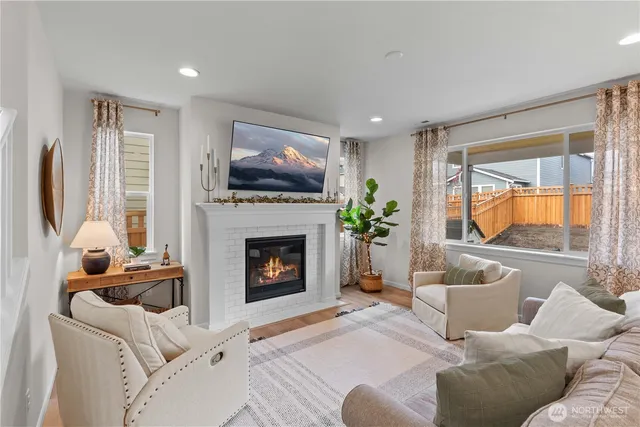 a living room with furniture a flat screen tv and a fireplace
