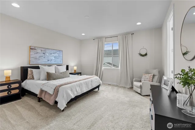 a spacious bedroom with a bed a couch and potted plant