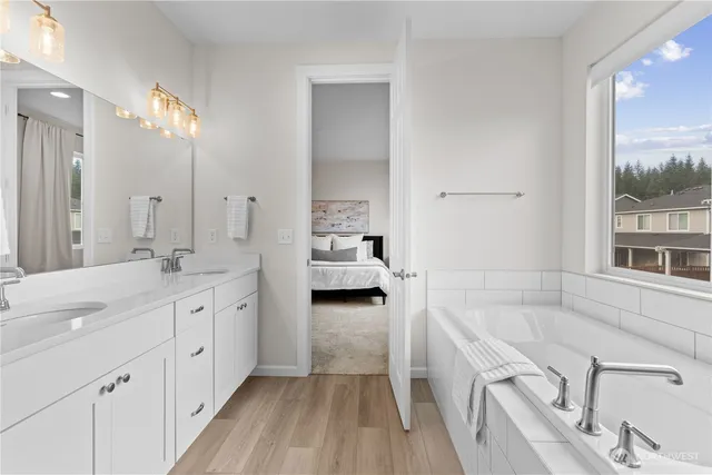 a bathroom with a tub sink and mirror
